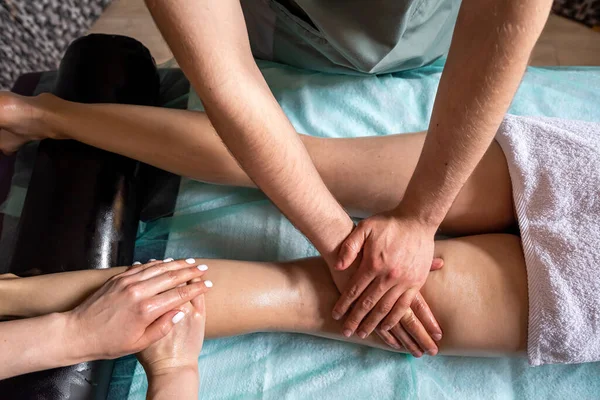 在一个现代美容院里用四只手按摩女性的脚 保健的概念 放松按摩 最好的专家 — 图库照片