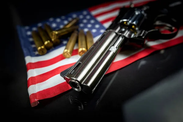 许多黄色的子弹和挂在美国国旗上的左轮手枪被隔离在一张黑色桌子上 在美国领土上或在美国射击场上贩运武器的概念 — 图库照片