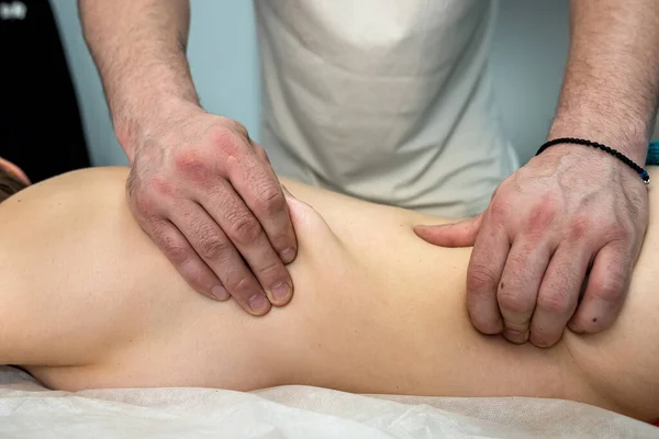 在温泉沙龙的按摩床上 与男性按摩师的手靠在一起按摩 又回到了他的女性客户身边 治疗师服务的概念 — 图库照片