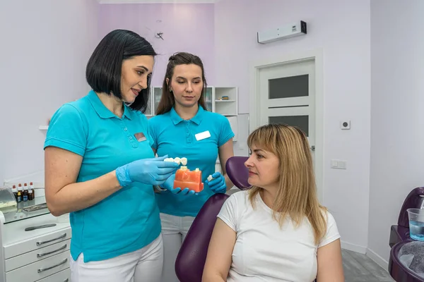 Una Dentista Una Asistente Femenina Tratan Los Dientes Una Paciente —  Fotos de Stock