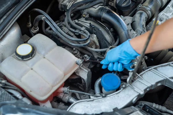 車の整備士の女性は壊れた車とガレージで働く 修理サービス 車を修理する女性の手のクローズアップ — ストック写真