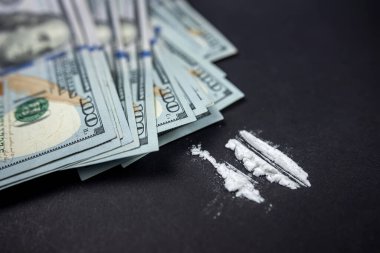 Siyah arka planda izole edilmiş yollara ayrılmış kokain ya da eroin. Yasadışı uyuşturucu kullanımı