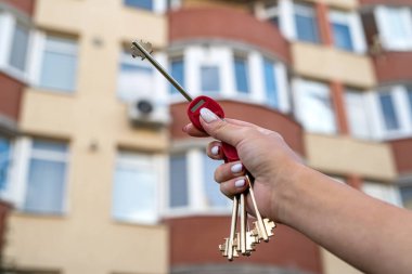 Evin anahtarlarını tutan güçlü bir emlakçının görüntüsü. Emlakçı ve apartmanın anahtarları. Anahtarlı el