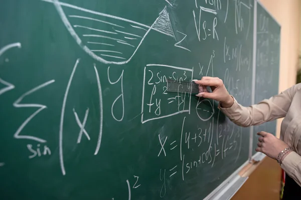 女性の手にチョークで数式を黒板に書きます 教育の概念です — ストック写真