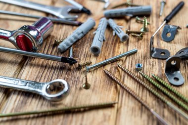 İzole ahşap arka planda asılı nesneler için vida ve paneller. onarım kavramı