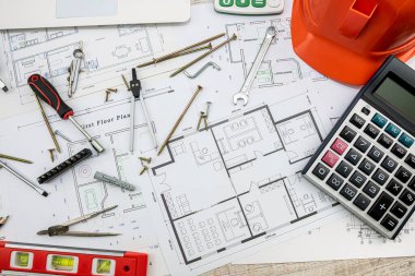 Taslak çizimler ve inşaat araçları inşaat arka planına saçılmış durumda. çizim araçları