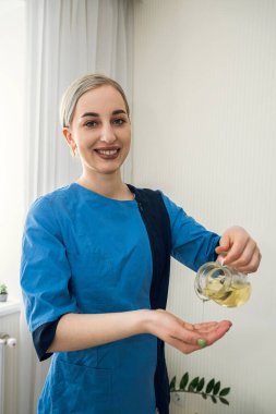 Masör masaj aletlerini tutar ve müşteriyi beklerken kameraya poz verir.