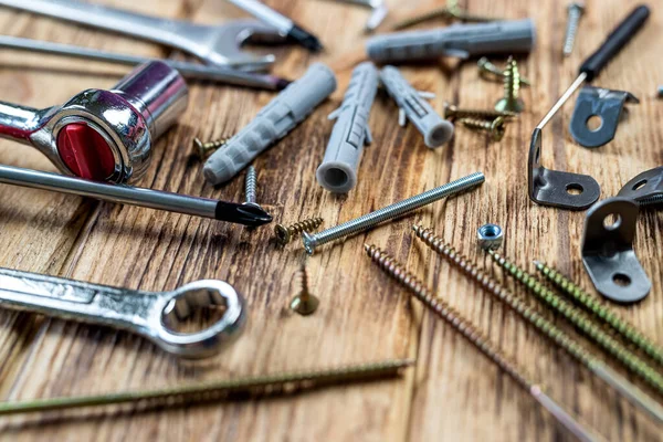 İzole ahşap arka planda asılı nesneler için vida ve paneller. onarım kavramı