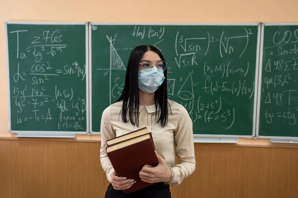 female teacher with mask learn math lesson at school during coronavirus pandemic, infection covid19. Social distanting