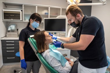 Güzel genç bir kız dişçiye profesyonel diş beyazlatma için geldi. Diş beyazlatıcı diş gülümsemesi