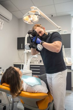 Diş hekimi, hastanın dişlerinin fotoğrafını çeker. Sonuçları kontrol etmek için. fotoğraf stomatolojisi