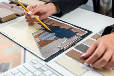 Daire tasarımı için seçilmiş ahşap bir numuneyle bir kadın tasarımcının elleri. Tasarım için odun örnekleri