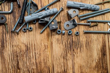 Plastik kaplama setlerinin yakın plan görüntüsü ve arka plandaki bir yığın içindeki parlak metal vidalar. Vida kapatır.