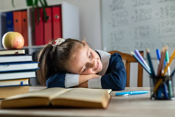 little student is sleeping on the school desk because she is tired. school. teaching. sleep