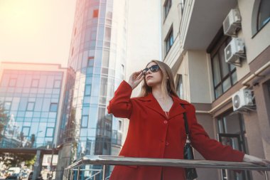 İş hayatında başarılı, takım elbiseli bir iş kadını kollarını kavuşturarak ofis binasının yanında duruyor. İş konsepti. Bir kadın portresi. Kadın patrondur. Kadın kariyeri