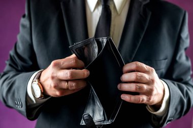 Banknotsuz, boş bir cüzdanı tutan şok olmuş bir adamın yakın çekimi. Adam iflas etmiş. Finansla ilgili sorunlar