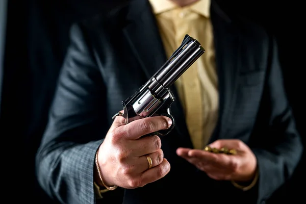 Businessman man in shirt and jacket with revolver isolated on black background. illegal business. a weapon in the hands of a bad person