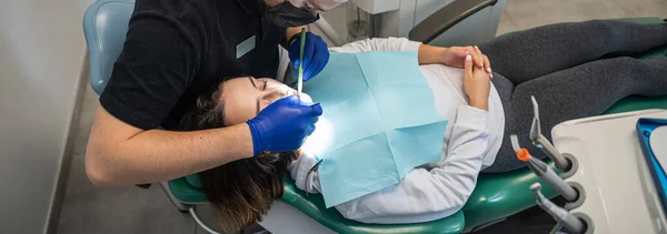 examination of a dentist treating a patient in a dental office. A woman has a scheduled dental examination at the dentist. dental problems