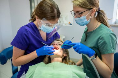 Doktor ve asistan, klinikteki kadın hastayı muayene ediyor. sağlık hizmetleri