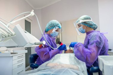 İç içe geçmiş diş sorunu olan bir hasta, bir dişçi ve asistanları tarafından ameliyat edildiği bir ameliyat sandalyesinde yatar. Dişçide ameliyat konsepti