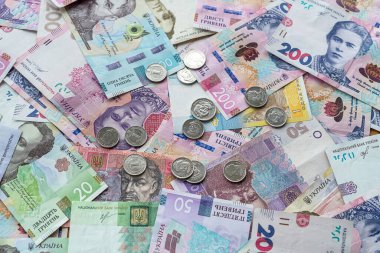 Ukraine money coins lying on  mixed hryvnia banknotes, background. finance concept 