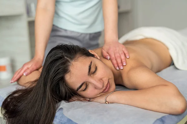 female therapist specialist makes anti-cellulite massage on back woman client at spa salon. health and beauty concept