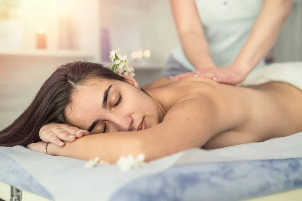 Young woman lying on table and receive relax massage on spa. Spine health concept