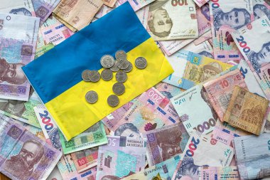 uah paper money hryvnia with coin on ukrainian national flag. financial concept. economy wealthy concept
