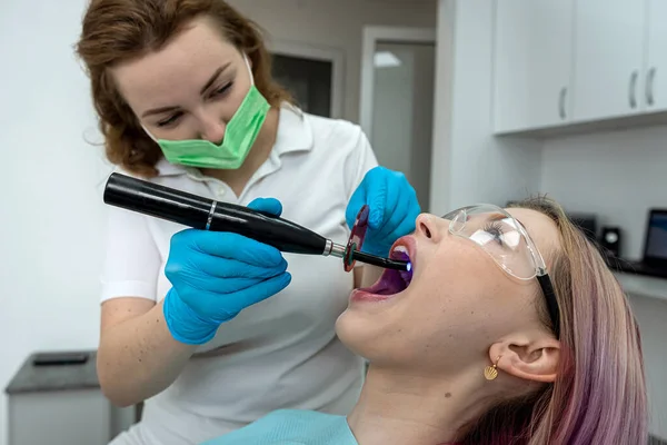 Ung Kvinde Besøger Tandklinik Professionel Tandbehandling Kvinde Tandlæge Bøje Sig - Stock-foto