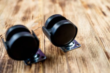 Bir ofis sandalyesi için mobilya çarkı ya da tekerlek masanın arka planına yerleştirilir. Yakın çekim görüntüsü. Mobilyalar için siyah tekerlekler