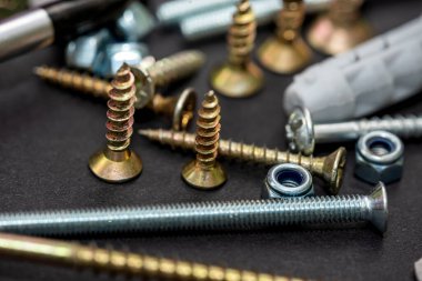 Vidalar ya da kendi kendine dokunan vidalar siyah bir ayna masasında düzgünce düzenlenir. onarım kavramı