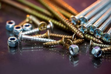 Masanın arka planında farklı boyutlarda vidalar ve vidalar var. Mobilya aksesuarları. Parçaları birleştiriyorum. Uyumaya gidiyorum..