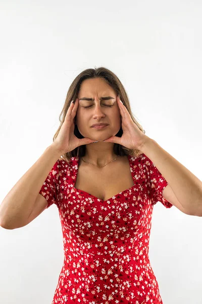 young woman is sick and has a headache isolated on a white background. hands by the head. pain in the wax