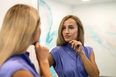 Beautiful girl with hairstyle in trendy t-shirt and blue vintage jeans posing in studio on isolated background. concept of shooting a girl in a studio