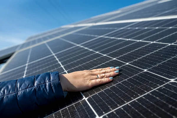Close up hand of young female engineer checking solar operation and cleanliness of photovoltaic solar panels in the sun. Concept renewable energy sources. technologies. electricity services future.
