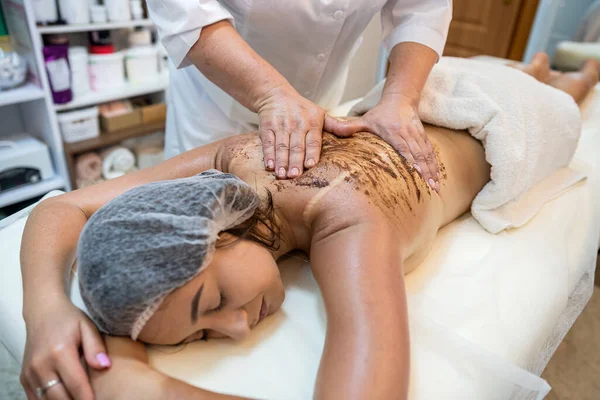 female client receives physical therapy from a massage therapist on her shoulders and back in a beauty spa. Healthy Lifestyle. healthy back back rehabilitation