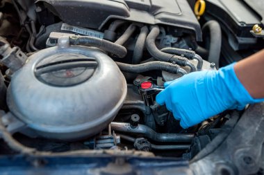 Otomotiv garajında araba motorunu tamir etmek için ingiliz anahtarı kullanan araba tamircisinin ellerine yakın çekim. Araba bakımı onarım ve servis kavramları.
