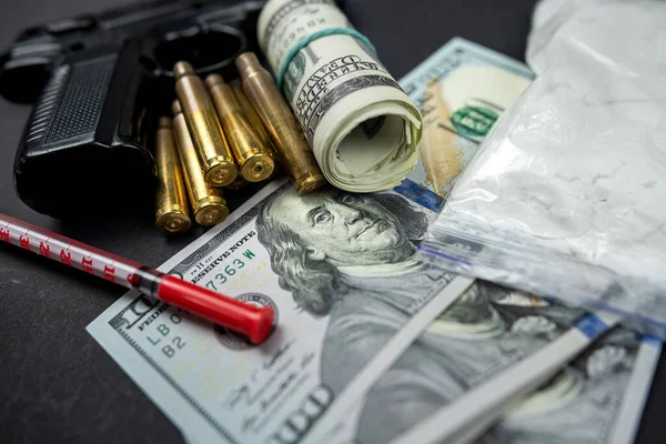 couple of dollars in gun on isolated on black table with syringe and cartridges. Sale and storage and distribution of drugs. Youth problems with drug addiction and law and crime. Drug trade.