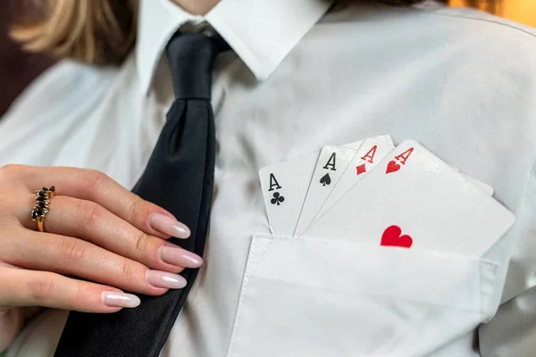 Cropped portrait of a girl where she pulls poker cards out of her white shirt pocket. cunning. poker game isolated