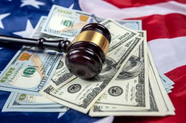 the gavel is placed together with dollars on the background of the flag of the United States of America. symbol of jurisdiction. Bribes in the justice system of the country
