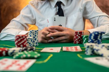 beautiful young girl is sitting at a poker table with cards in her hands. poker game of chance. woman's hands hold poker cards. isolated