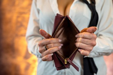 Close-up image of girl's hands with an open empty purse in her hands. An empty wallet is a woman without money in her wallet. Wallet made of natural blue leather