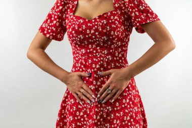 Beyaz arka planda iç çamaşırının yanında el ele tutuşan güzel bir kadın. Jinekoloji. Bir kadın için kritik günler