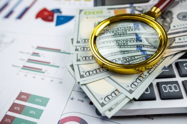 business graph chart paper pen calculator us dollar magnifying glass on office desk. Checking financial reports.