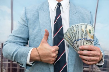 close up of 100 one hundred dollars bills in a man's hand. money concept