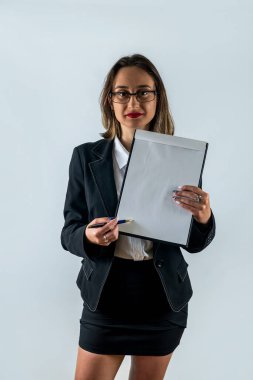 Resmi kıyafetli bir kadının tam boy portresi elinde pano ve beyaz arka planda izole edilmiş kameraya gülümsüyor. İş. İş kadını. Bir kadın portresi. İş elbiseli kadın.