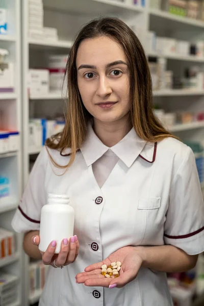 A female pharmacist checks the shelves for the presence of drugs. Pharmacy and pharmacist concept