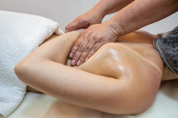 Gentle female hands of a professional woman masseur doing a back massage in a health spa beauty center. concept of wellness treatment