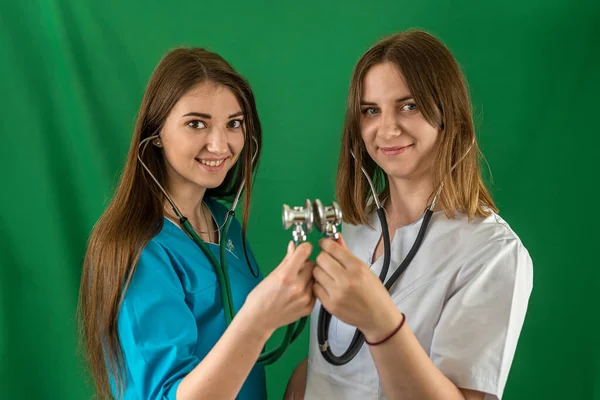 Team of two female doctors standing back to back with crossed arms isolated on a certain background. medicine. portrait of women. love of medicine