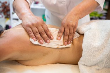 female client receives physical therapy from a massage therapist on her shoulders and back in a beauty spa. Healthy Lifestyle. healthy back back rehabilitation